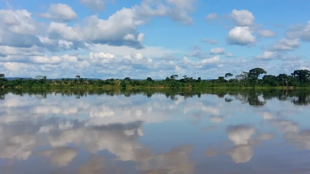 Nubes reflejadas en las aguas del río Mamoré durante la travesía en barco.