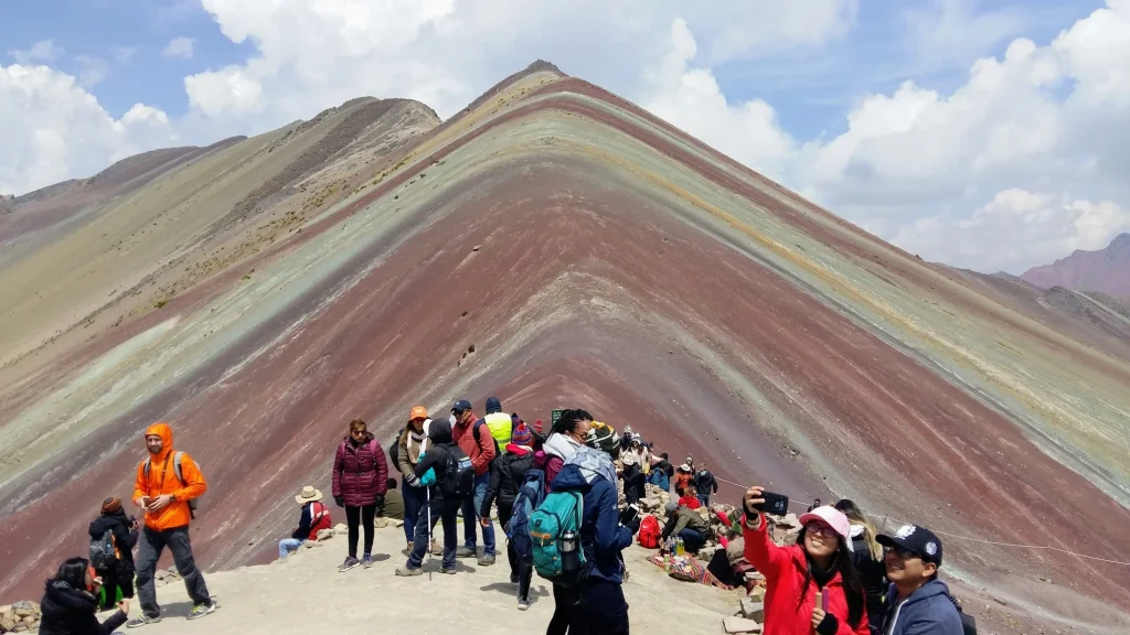 Montaña de los 7 Colores, Perú Visitantes en la Montaña de los 7 Colores, en Perú, frente al paisaje de franjas minerales.